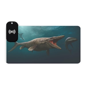 Könnte beinhalten: Rechteckiges Mauspad mit einer prähistorischen Unterwasserszene. Es zeigt einen großen Mosasaurier und einen Delfin. Ein schwarzes kabelloses Ladepad ist in der oberen linken Ecke angebracht.