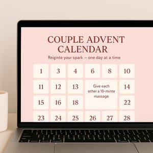 以下が含まれることがあります： ノートパソコンの画面には、「COUPLE ADVENT CALENDAR」と「Reignite your spark - one day at a time」というテキストが表示されています。カレンダーには番号付きの正方形があり、1つは10分間のマッサージを提案しています。画面は薄いピンク色の背景に設定されています。