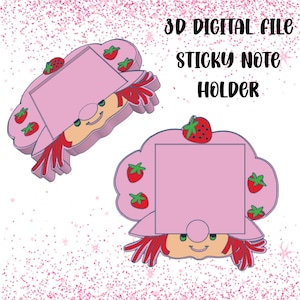 May include: Two pink 3D digital file sticky note holders. Each holder is shaped like a cartoon character with a pink hat, red hair, and a smiling face. The hat is decorated with red strawberries.