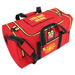 May include: A red duffel bag with black straps and yellow accents. The bag features the text "YOUR NAME HERE" and a "FIRE DEPT" emblem. It has a zippered top and multiple compartments, designed for carrying equipment.