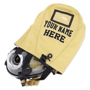 Könnte beinhalten: Eine feuerfeste Kapuze in Beige mit einem transparenten rechteckigen Fenster und dem Text "YOUR NAME HERE" in Schwarz. Die Kapuze ist mit einer schwarzen und transparenten Atemschutzmaske mit Riemen und einer Schnalle kombiniert.