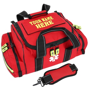 Könnte beinhalten: Eine rote medizinische Tasche mit schwarzen Akzenten, einem weißen medizinischen Symbol und dem Text "YOUR NAME HERE" in Gelb. Die Tasche hat mehrere Fächer, Reißverschlüsse und einen abnehmbaren Schultergurt.