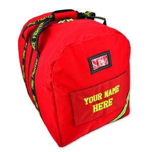 May include: A red duffel bag with black and yellow accents. The bag has a clear window and a pocket with the text "YOUR NAME HERE" in yellow. The straps have "FIRE FIGHTER" printed on them.