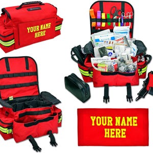 Puede incluir: Bolsa médica roja con múltiples compartimentos y un asa. La bolsa tiene texto amarillo que dice "YOUR NAME HERE". La bolsa está abierta, revelando varios suministros médicos, incluyendo vendas, tijeras y medicamentos. También se ve una bolsa negra y un letrero rectangular rojo con texto amarillo.