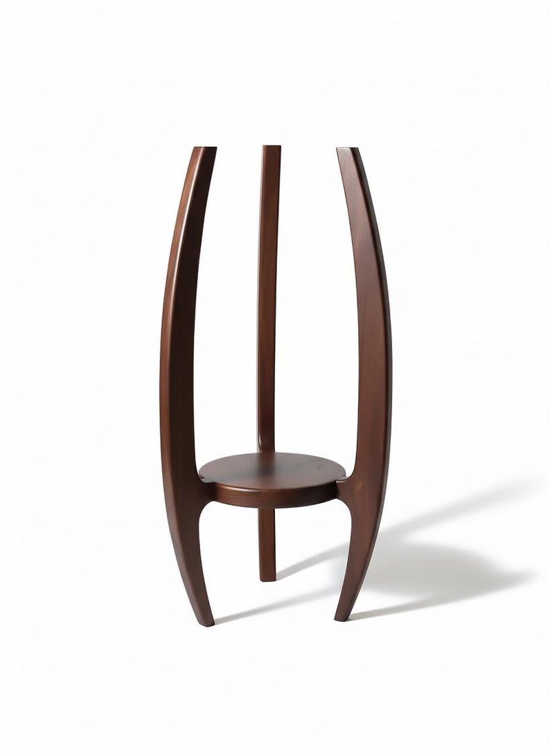 May include: A dark brown wooden plant stand with a round shelf and three legs. The stand has a curved design with two outer supports and a central support, creating a modern aesthetic.