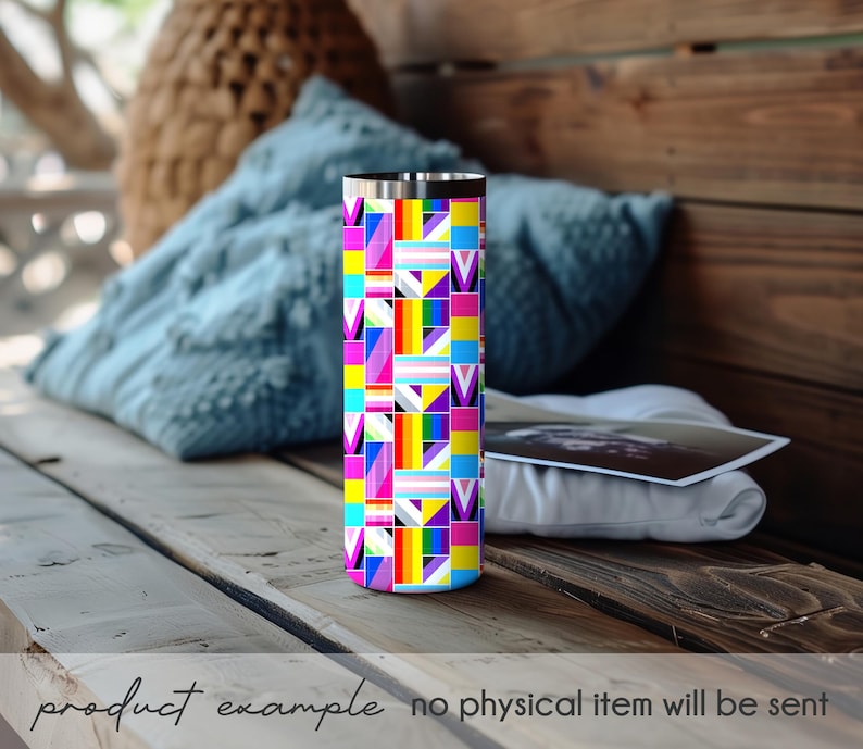 Puede incluir: Un vaso de acero inoxidable con un colorido dise&ntilde;o geom&eacute;trico que presenta rayas de arco&iacute;ris y s&iacute;mbolos de la bandera del orgullo transg&eacute;nero. El vaso cil&iacute;ndrico est&aacute; sobre una superficie de madera. El texto en la parte inferior dice "product example no physical item will be sent."