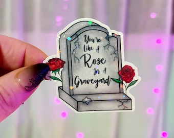 Naklejka „Jesteś jak róża na cmentarzu”: Laminowana, wodoodporna naklejka dla czytelnika z brokatem