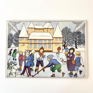 Puede incluir: Una postal vintage que representa una escena invernal con niños patinando y jugando al hockey sobre hielo en un estanque helado. Un edificio amarillo con un diseño de castillo se encuentra en el fondo. La ilustración tiene un estilo caprichoso de cuento.