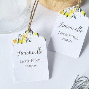 May include: Two white gift tags with a lemon and flower design. The tags say "Limoncello" and "Leonie & Sam 25.09.24".