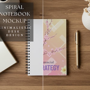 Può includere: Mockup di taccuino a spirale con un design da scrivania minimalista. Il taccuino presenta un design floreale con fiori rosa e le parole "financial strategy". Una penna d'oro e un piccolo vaso con fiori sono anche sulla scrivania di legno.