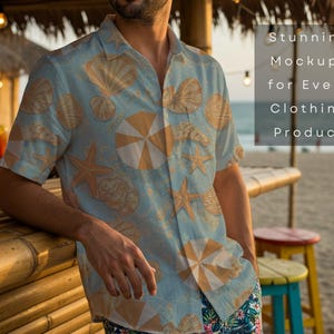 May include: A light blue button-down shirt with a seashell and umbrella pattern. The shirt is part of a clothing product mockup. The text on the image reads "Stunning Mockups for Every Clothing Product". The shirt is worn at a beach bar.