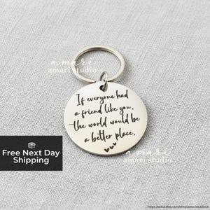 Può includere: Un portachiavi rotondo color argento con la scritta "If everyone had a friend like you, the world would be a better place." Il portachiavi ha un piccolo anello e un anello più grande. Il testo è in stile manoscritto.