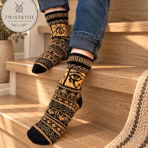May include: A pair of mid-calf knit socks featuring a black and golden-yellow color scheme with intricate geometric patterns and an Eye of Horus motif. The socks are worn with blue denim jeans, showcasing a detailed jacquard knit design.