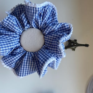 Puede incluir: Una taza de cerámica blanca con un asa negra y el texto "But First, Coffee" en negrita negra. La taza está sobre una superficie de madera. La taza mide aproximadamente 10 cm de alto.