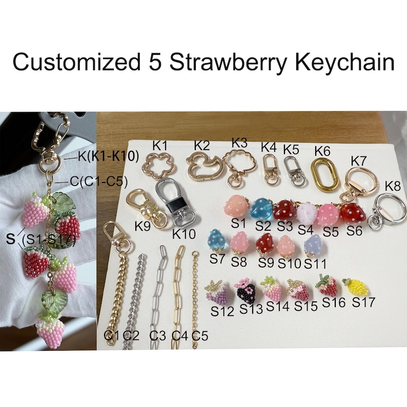 Pu&ograve; includere: Una collezione di portachiavi a forma di fragola personalizzati. I portachiavi presentano vari design, tra cui fragole di perline rosa, rosse e bianche, insieme a diversi stili di catene e chiusure. Il testo "Customized 5 Strawberry Keychain" &egrave; in alto.