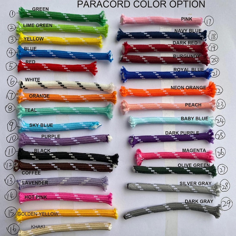May include: A colour chart titled PARA CORD COLOR OPTION displaying twenty-nine numbered samples of braided paracord in various solid and patterned colours including green, yellow, blue, red, white, orange, teal, purple, black, pink, and grey.