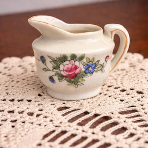 May include: A set of three ceramic mugs with a speckled, matte finish. The mugs are in shades of cream, light brown, and dark brown. Each mug has a simple, minimalist design, perfect for coffee or tea.