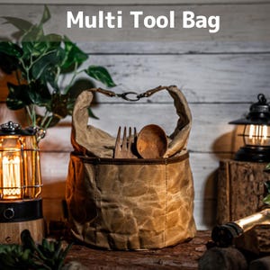 May include: A brown canvas Multi Tool Bag with a leather handle and a metal clasp. The bag contains a wooden fork and spoon. The text "Multi Tool Bag" is displayed at the top of the image.