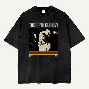 May include: Black t-shirt featuring a graphic from "The Fifth Element" movie. The design includes a vintage-style image of the film's characters, the movie title, and the year "1997" in a retro font. The shirt has a classic crew neck and short sleeves.