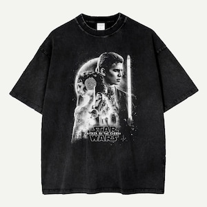 May include: Black t-shirt featuring a Star Wars graphic. The design includes characters and the text "Star Wars: Attack of the Clones" in white. The shirt has a vintage, faded look.