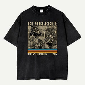May include: Black t-shirt featuring a graphic of Bumblebee from Transformers. The design includes images of the character and the text "BUMBLEBEE TRANSFORMERS 2007" with a retro color stripe.