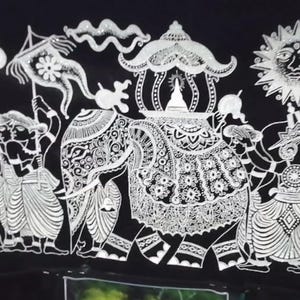 Puede incluir: Ilustración en blanco y negro de una procesión con figuras, un elefante y un sol con rostro. Las figuras visten ropa tradicional y portan banderas y paraguas. El elefante está adornado con elementos decorativos.