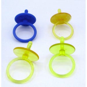 May include: Four plastic rings in the shape of pacifiers. One is blue, and the other three are yellow and green. The rings have a circular band and a flat, round top.