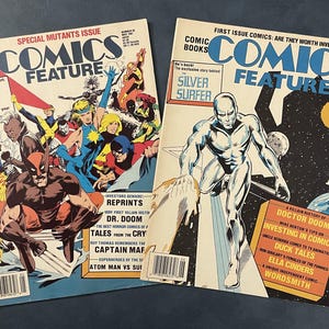 May include: Two vintage "Comics Feature" magazines. One features a group of colorful superheroes, and the other showcases the Silver Surfer. The magazines have the text "Special Mutants Issue" and "First Issue Comics" on the covers.