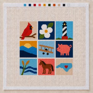 May include: A square needlepoint canvas featuring a grid of nine colorful icons including a red cardinal, a white flower, a black and white lighthouse, a sunset over mountains, a biplane, a pink pig, cattails, a brown horse, and a map of North Carolina.