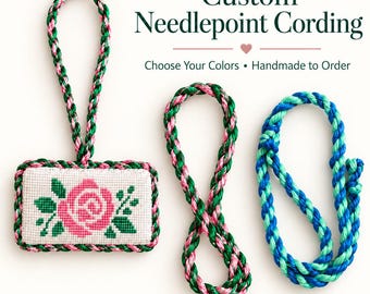 Könnte beinhalten: Custom Needlepoint Cording, Choose Your Colors, Handmade to Order. Ein rechteckiges Stickstück mit einem rosa Rosenmotiv, eingefasst mit einer geflochtenen grün-rosa Kordel. Zwei zusätzliche Stücke geflochtene Kordel, eine grün-rosa und eine blau.