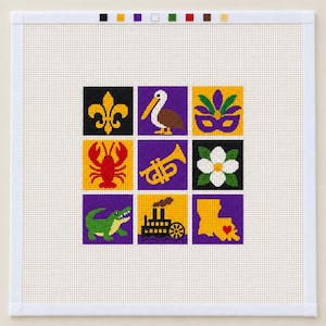 May include: A square needlepoint canvas featuring a grid of nine colorful icons including a fleur-de-lis, pelican, mask, lobster, trumpet, flower, alligator, steamboat, and a map of Louisiana with a heart, plus a color key at the top edge.