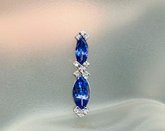 May include: A silver pendant with three marquise-shaped blue gemstones and small diamonds set in a delicate design.