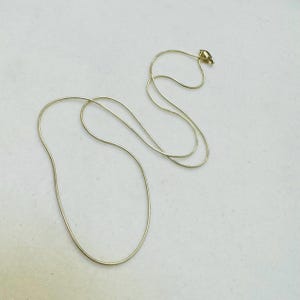 May include: A gold chain necklace with a lobster clasp.