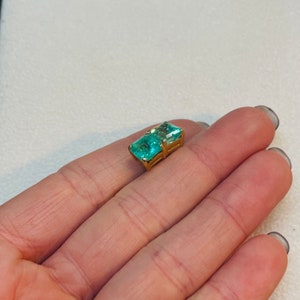 May include: A gold ring with a large, rectangular, emerald-cut, light blue gemstone.