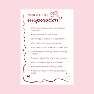 May include: A white card with the text "NEED A LITTLE inspiration?" in a handwritten style. Below, a list of prompts includes questions about memories, wishes, and advice. The card has a pink border with hearts and stars.
