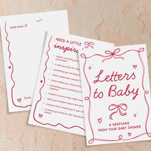 May include: A set of baby shower stationery with red accents. The set includes a lined letter sheet with the text "Dear Baby" and "Love," and two cards. One card reads "Letters to Baby" and the other has prompts.