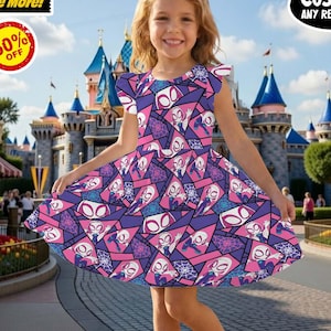 May include: A young girl wearing a sleeveless dress with a geometric pattern in shades of purple, pink, and white. The dress features a character design. The background shows a theme park with a castle and shops. The image includes text that says "Buy More, Save More!" and "50% OFF".