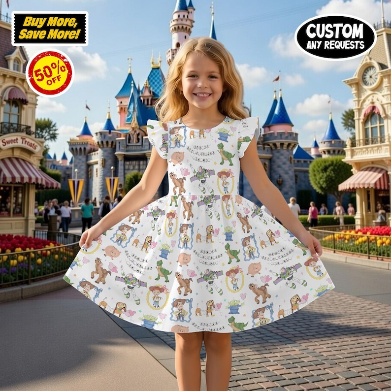 Puede incluir: Un vestido blanco con un estampado de personajes de Toy Story. El vestido tiene mangas cortas y una falda acampanada. El fondo muestra un parque tem&aacute;tico con un castillo y tiendas. El vestido tiene el texto "Buy More, Save More!" y "50% OFF".