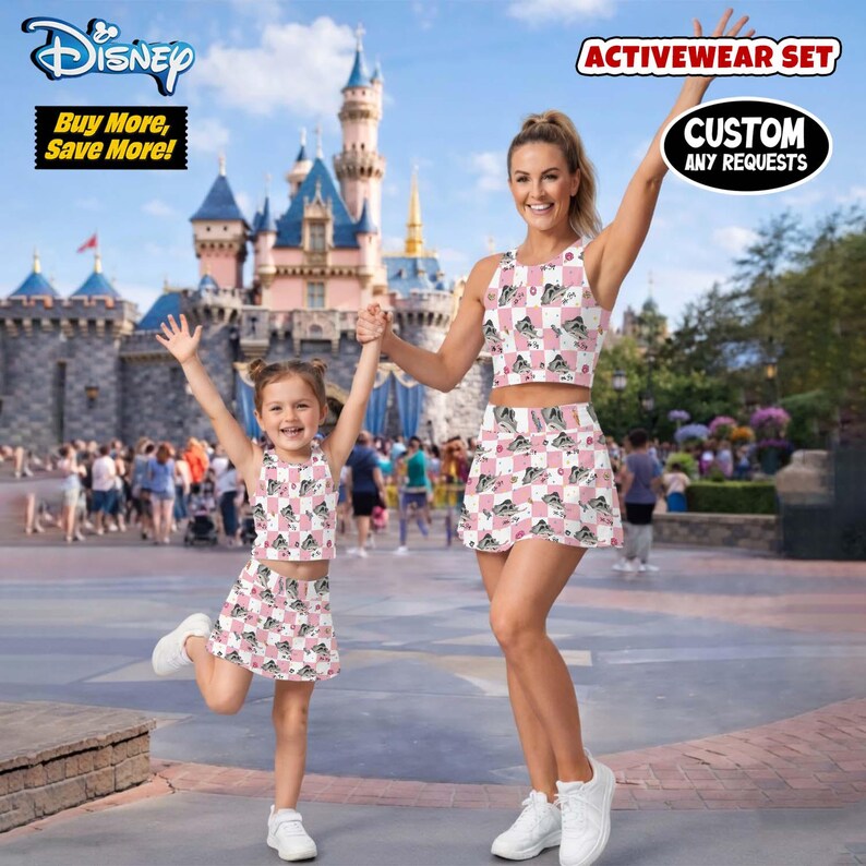 May include: Matching activewear sets for mother and child. The sets include crop tops and skirts with a pink and white checkered pattern featuring a cartoon image. The image also includes the text "Disney" and "Buy More, Save More!"