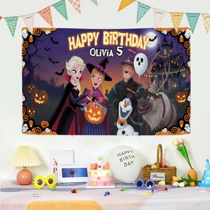 May include: A large birthday banner with the text "HAPPY BIRTHDAY OLIVIA 5" features characters from the movie Frozen in a Halloween-themed setting. The banner is decorated with pumpkins, bats, and a haunted house. Party decorations are in the foreground.