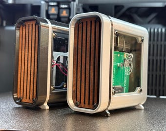 May include: Two rectangular computer cases with a wood-grain front panel and a clear side panel. The cases have a silver frame and are sitting on a dark surface. One case has a green circuit board visible.