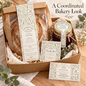 May include: A brown cardboard gift box containing a loaf of sourdough bread in a paper bag, a glass jar with a red label, and two rectangular cards. All items feature a botanical line art design with a windmill and wheat illustrations.