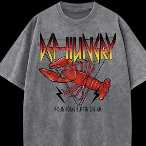 May include: Gray t-shirt with a red lobster graphic and the text "DEF-HUNGRY" in yellow and red. Below the lobster is the text "POUR SOME BUTTER ON ME" in black.