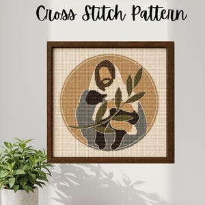 Könnte beinhalten: Ein gerahmtes Kreuzstichmuster mit einer Figur, die Olivenzweige hält, in einem kreisförmigen Design. Das Kunstwerk verwendet gedämpfte Töne von Braun, Beige und Grün. Der Text "Cross Stitch Pattern" befindet sich über dem Rahmen.
