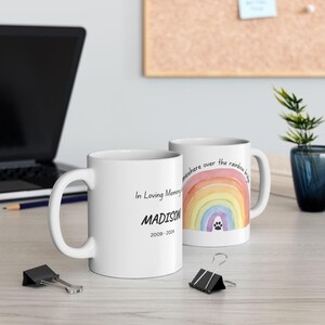 May include: Two white ceramic mugs. One mug has the text "In Loving Memory MADISON 2009-2024". The other mug has a watercolor rainbow design with a paw print and the text "somewhere over the rainbow bridge".