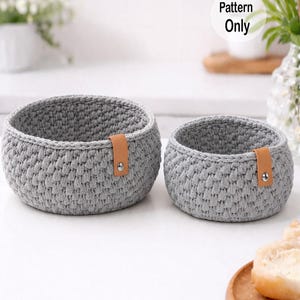 May include: A set of three ceramic mugs with a speckled, matte finish. Each mug features a different color: light blue, cream, and gray. The mugs have a simple, modern design with a rounded shape and a handle.