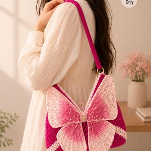 Puede incluir: Un bolso de ganchillo con una base de color magenta vibrante y una gran aplicación de mariposa en rosa degradado en la parte frontal. Las alas de la mariposa están adornadas con pequeñas cuentas blancas y un botón central en forma de corazón. Incluye una correa magenta y el texto Pattern Only.