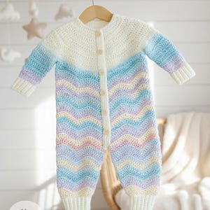 May include: A handmade crochet baby romper in a chevron pattern. The romper features a color gradient of white, blue, lavender, and yellow. It has long sleeves, a button-up front, and is displayed on a wooden hanger. The text "pattern Only" is visible.