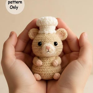 Könnte beinhalten: Eine gehäkelte Maus mit Kochmütze. Die Maus ist hellbraun mit schwarzen Augen, rosa Nase und Pfoten sowie einem weißen Hut. Der Text "pattern Only" befindet sich in einem weißen Kreis oben links.