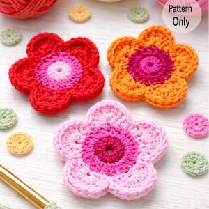 Op de afbeelding: Drie kleurrijke, gehaakte bloemapplicaties in rood, oranje en roze, met kleinere gehaakte cirkels verspreid. De bloemen hebben een gelaagd ontwerp met een centrale cirkel en bloembladachtige randen. De tekst "Pattern Only" is zichtbaar.